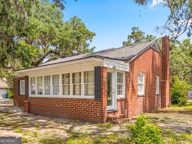 805 First Ave, Brunswick, GA 31520 - view of side of property with brick siding, a chimney, and entry steps