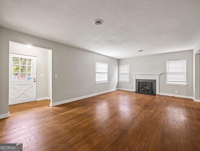 805 First Ave, Brunswick, GA 31520 - unfurnished living room featuring hardwood / wood-style flooring, healthy amount of natural light, and a brick fireplace