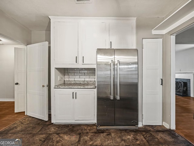 805 First Ave, Brunswick, GA 31520 - kitchen featuring stainless steel built in refrigerator, white cabinetry, tasteful backsplash, and a fireplace