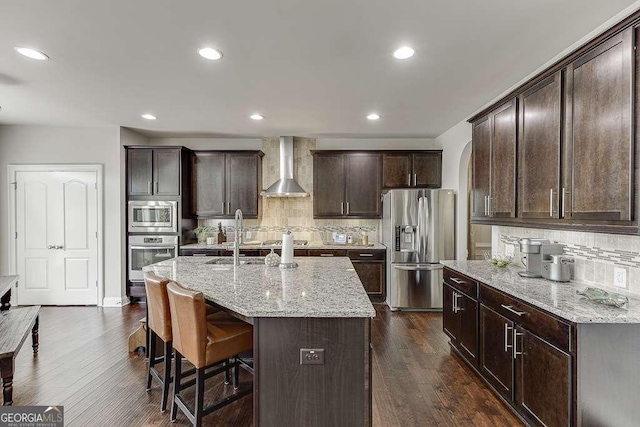 1830 Secretariat Gait Way, Suwanee, GA 30024 - kitchen featuring appliances with stainless steel finishes, wall chimney range hood, backsplash, dark wood-style flooring, and recessed lighting