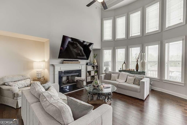 1830 Secretariat Gait Way, Suwanee, GA 30024 - living room with a towering ceiling, a ceiling fan, a fireplace, and dark wood-type flooring