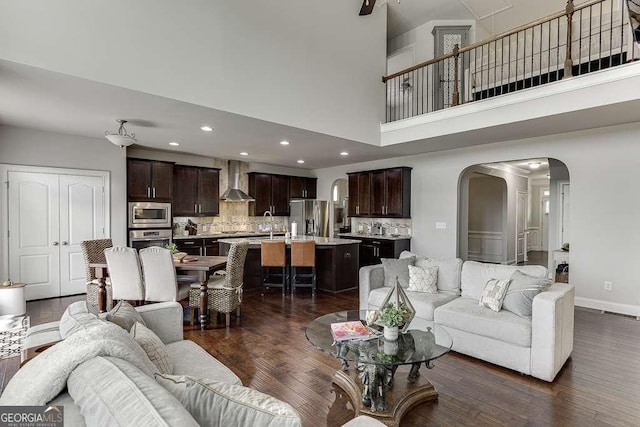 1830 Secretariat Gait Way, Suwanee, GA 30024 - living area with arched walkways, dark wood-type flooring, recessed lighting, and a high ceiling
