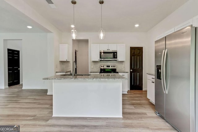 307 E Pine St E, Rockmart, GA 30153 - kitchen featuring appliances with stainless steel finishes, light stone counters, light wood-style flooring, white cabinets, and decorative backsplash