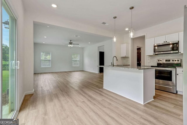 307 E Pine St E, Rockmart, GA 30153 - kitchen with stainless steel appliances, white cabinetry, light stone countertops, light wood-type flooring, and recessed lighting