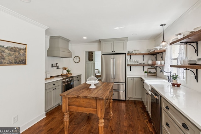 5095 Karr Rd, Cumming, GA 30040 - kitchen with appliances with stainless steel finishes, premium range hood, open shelves, gray cabinetry, and dark wood finished floors