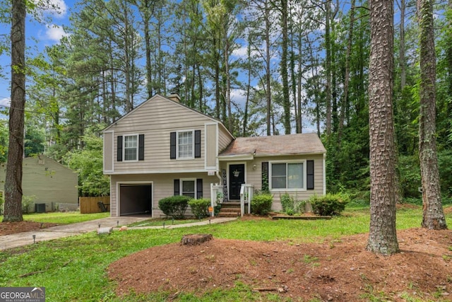 447 Sherwood Cir, Stone Mountain, GA 30087 - split level home featuring concrete driveway, a garage, a front yard, and a chimney