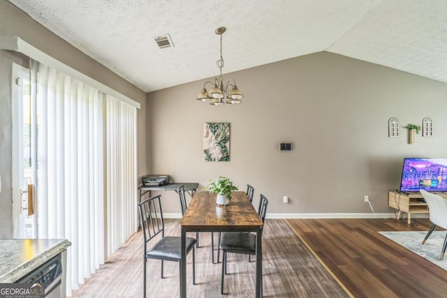 447 Sherwood Cir, Stone Mountain, GA 30087 - dining area with a chandelier, wood finished floors, lofted ceiling, and a textured ceiling