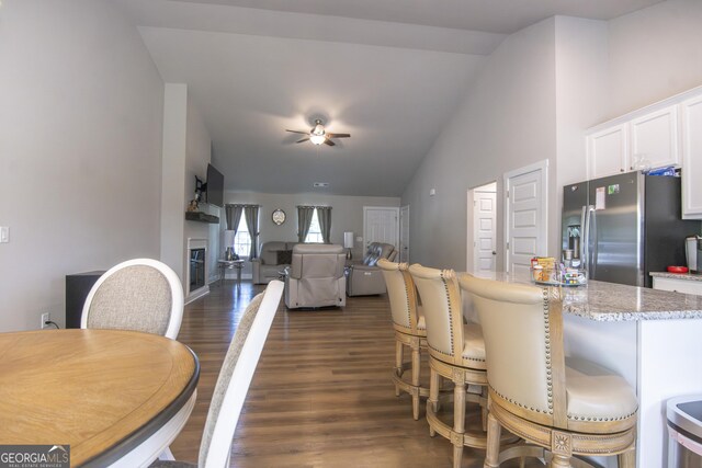 11 Rachel Ln, Hartwell, GA 30643 - dining area featuring vaulted ceiling, a glass covered fireplace, a ceiling fan, and dark wood finished floors
