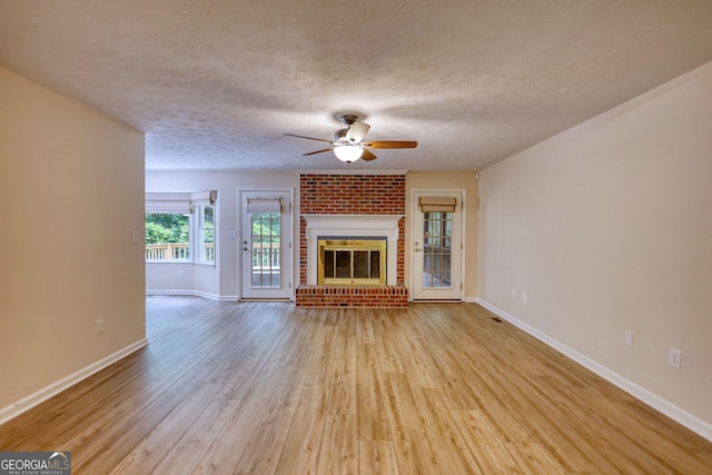 120 Fox Hunt Pl, Athens, GA 30606 - unfurnished living room featuring a ceiling fan, wood finished floors, a fireplace, and a textured ceiling