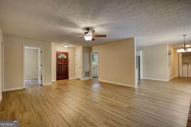 120 Fox Hunt Pl, Athens, GA 30606 - unfurnished living room featuring separate washer and dryer, a ceiling fan, a chandelier, a textured ceiling, and light wood-style flooring