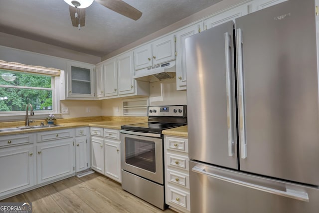 120 Fox Hunt Pl, Athens, GA 30606 - kitchen featuring stainless steel appliances, under cabinet range hood, light wood-type flooring, white cabinets, and light countertops