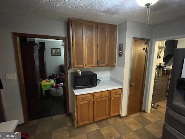 1791 Little Fawn Trl NW, Conyers, GA 30012 - kitchen with black microwave, light countertops, brown cabinets, and a textured ceiling