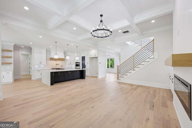 3205 Bold Springs Rd, Dacula, GA 30019 - unfurnished living room featuring light wood-style floors, beam ceiling, a chandelier, recessed lighting, and stairs