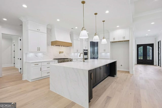 3205 Bold Springs Rd, Dacula, GA 30019 - kitchen with custom range hood, light wood finished floors, white cabinetry, recessed lighting, and backsplash