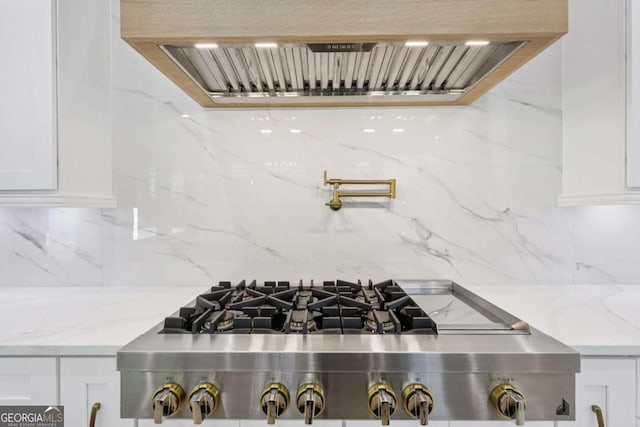 3205 Bold Springs Rd, Dacula, GA 30019 - kitchen view of pot filler, stainless steel gas stovetop, tasteful backsplash, and white cabinets