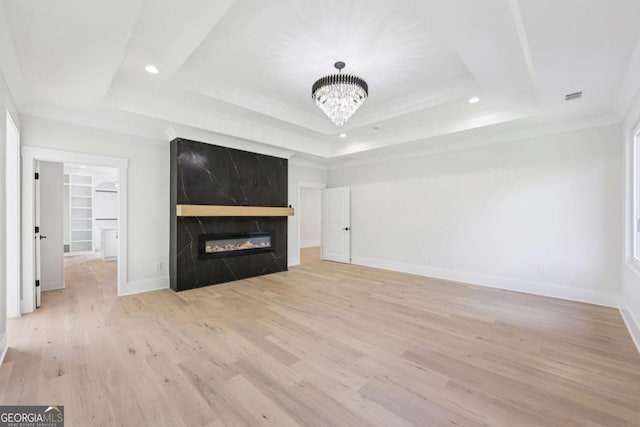 3205 Bold Springs Rd, Dacula, GA 30019 - unfurnished living room with a tray ceiling, light wood-type flooring, recessed lighting, a chandelier, and a premium fireplace