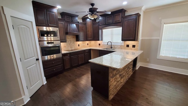 90 Alcovy Reserve Way, Covington, GA 30014 - kitchen featuring stainless steel appliances, a peninsula, dark brown cabinetry, premium range hood, and crown molding