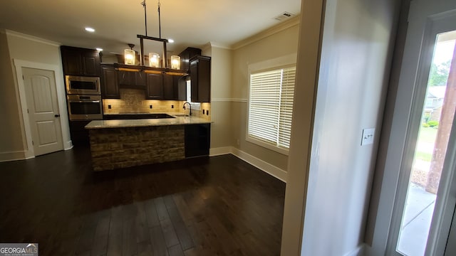 90 Alcovy Reserve Way, Covington, GA 30014 - kitchen featuring appliances with stainless steel finishes, ornamental molding, tasteful backsplash, light stone counters, and a peninsula