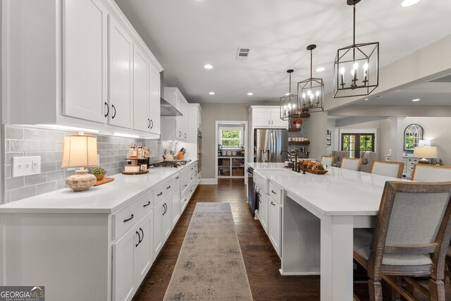 4813 Jess Helton Rd, Gainesville, GA 30506 - kitchen with appliances with stainless steel finishes, a chandelier, recessed lighting, a kitchen bar, and white cabinets