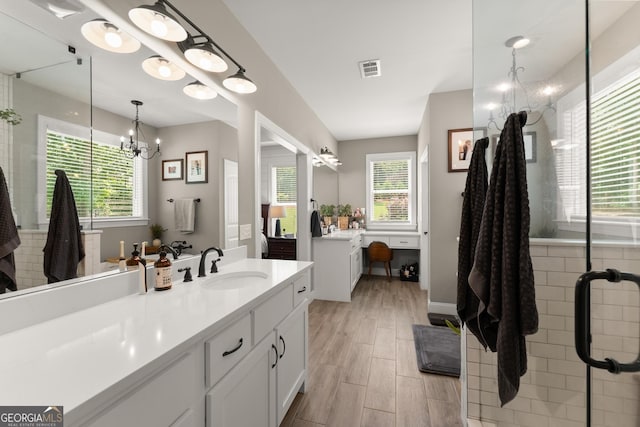 4813 Jess Helton Rd, Gainesville, GA 30506 - bathroom featuring a chandelier, vanity, wood finished floors, and a shower with door