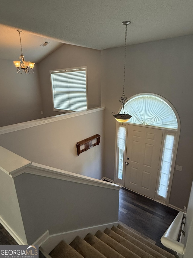 330 Anchors Way, Winder, GA 30680 - entryway with a chandelier, dark wood finished floors, vaulted ceiling, and a textured ceiling