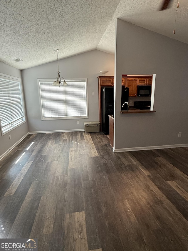 330 Anchors Way, Winder, GA 30680 - unfurnished living room with dark wood-style floors, lofted ceiling, a textured ceiling, and a ceiling fan