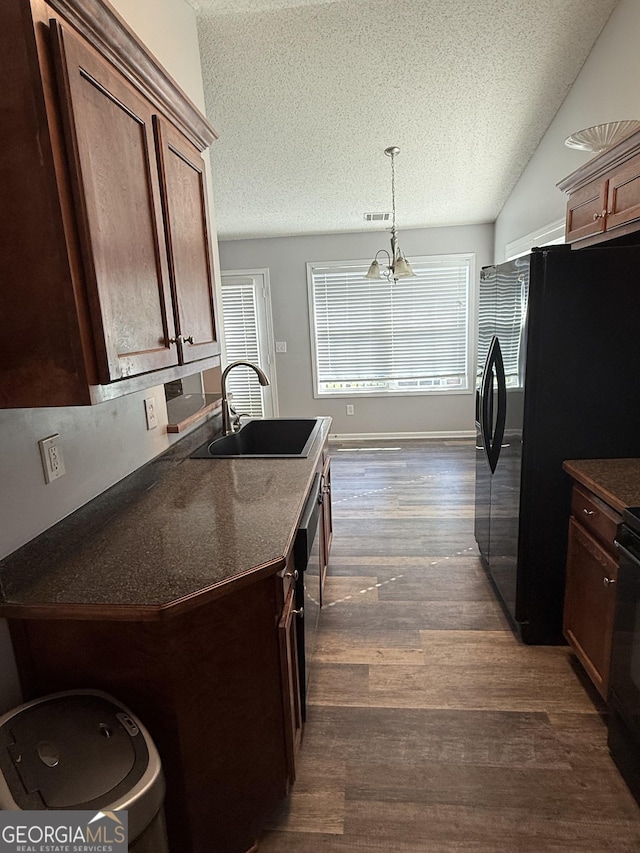 330 Anchors Way, Winder, GA 30680 - kitchen featuring dark countertops, a textured ceiling, dark wood-type flooring, freestanding refrigerator, and a chandelier