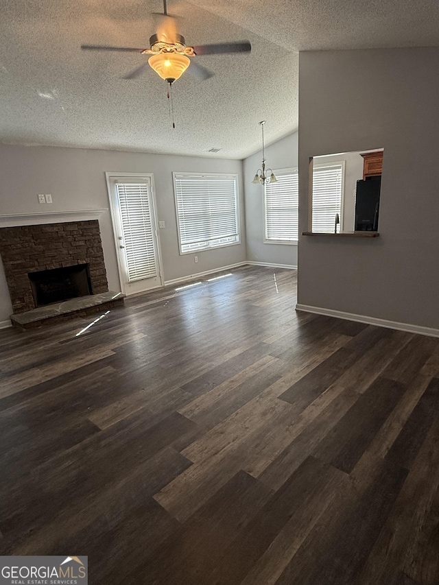 330 Anchors Way, Winder, GA 30680 - unfurnished living room featuring ceiling fan, a textured ceiling, a fireplace, dark wood-style flooring, and a chandelier