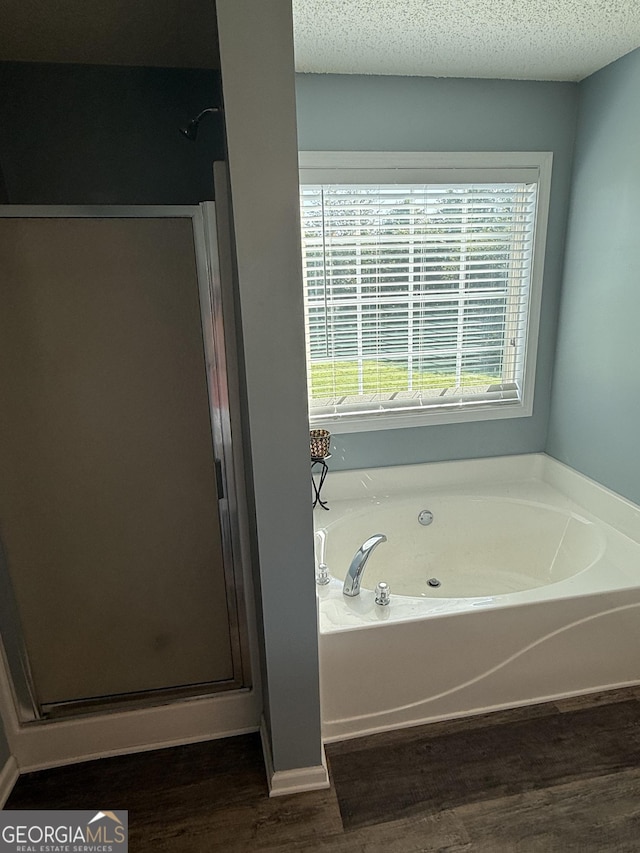 330 Anchors Way, Winder, GA 30680 - bathroom with a stall shower, a bath, wood finished floors, and a textured ceiling