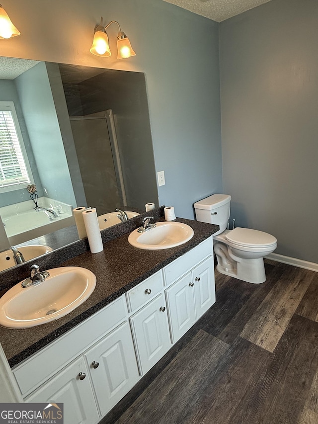 330 Anchors Way, Winder, GA 30680 - bathroom featuring double vanity, a garden tub, wood finished floors, a textured ceiling, and a shower