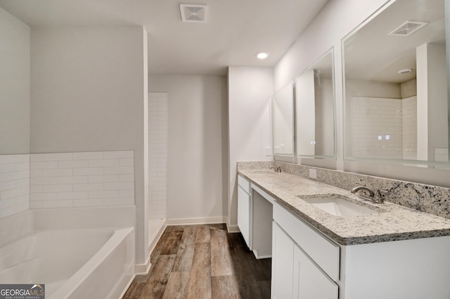 1184 Bluecoat Cir Unit 84, Hampton, GA 30228 - full bath with wood finished floors, double vanity, a bath, and recessed lighting
