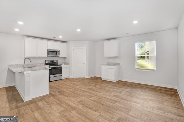 1184 Bluecoat Cir Unit 84, Hampton, GA 30228 - kitchen featuring stainless steel appliances, a peninsula, light wood-type flooring, and recessed lighting