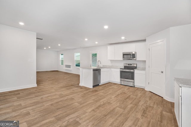 1184 Bluecoat Cir Unit 84, Hampton, GA 30228 - kitchen featuring appliances with stainless steel finishes, open floor plan, a peninsula, white cabinets, and recessed lighting