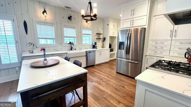 420 Ashbury Cir, Dallas, GA 30157 - kitchen featuring appliances with stainless steel finishes, range hood, light wood-style flooring, and a chandelier