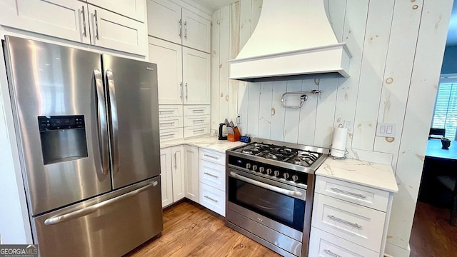 420 Ashbury Cir, Dallas, GA 30157 - kitchen with stainless steel appliances, custom range hood, light wood-style floors, and light stone countertops