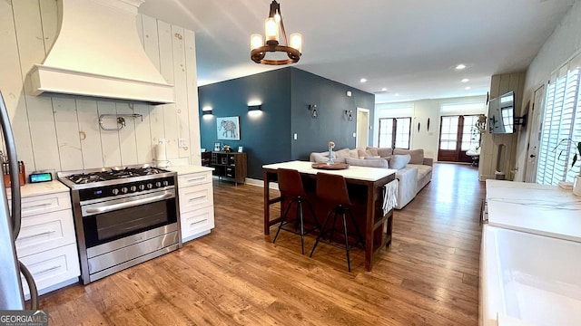 420 Ashbury Cir, Dallas, GA 30157 - kitchen with custom range hood, stainless steel gas stove, light wood-type flooring, light countertops, and a chandelier
