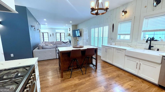 420 Ashbury Cir, Dallas, GA 30157 - kitchen with stainless steel gas stove, light wood-style floors, a chandelier, white cabinets, and recessed lighting