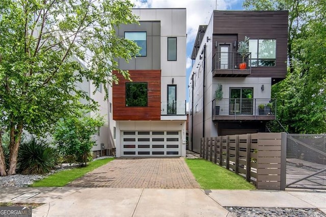 167 Sampson St, Atlanta, GA 30312 - contemporary house with decorative driveway, an attached garage, a balcony, and stucco siding