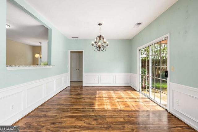 5035 Foxberry Ln, Roswell, GA 30075 - unfurnished dining area featuring a chandelier, wood finished floors, a wainscoted wall, and a decorative wall