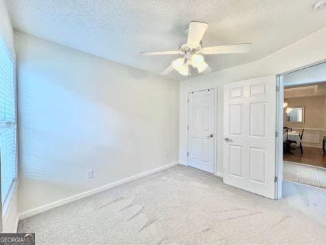 121 Pinnacle Ln, Mcdonough, GA 30253 - unfurnished bedroom featuring carpet, a textured ceiling, a closet, and ceiling fan
