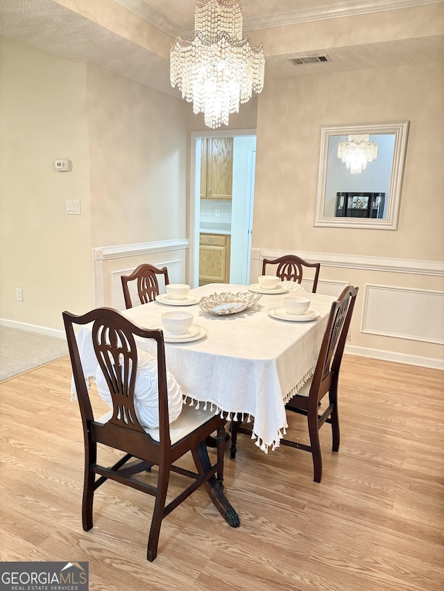 121 Pinnacle Ln, Mcdonough, GA 30253 - dining area featuring a chandelier, light wood-type flooring, and crown molding
