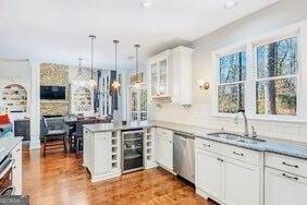 380 Victorian Ln, Duluth, GA 30097 - kitchen featuring dishwasher, wine cooler, white cabinetry, a peninsula, and hanging light fixtures