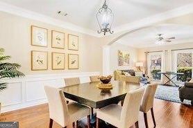 380 Victorian Ln, Duluth, GA 30097 - dining area with arched walkways, wood finished floors, a chandelier, a decorative wall, and wainscoting