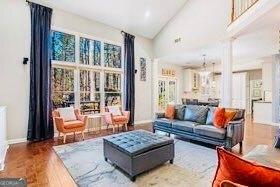 380 Victorian Ln, Duluth, GA 30097 - living area with high vaulted ceiling, wood finished floors, and ornate columns
