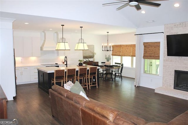 688 Harmony Rd, Temple, GA 30179 - living room featuring a ceiling fan, dark wood-style flooring, recessed lighting, a large fireplace, and a chandelier