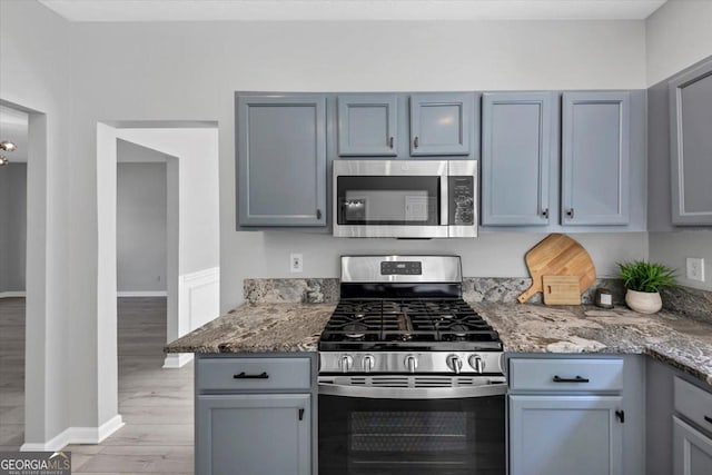 5195 Oaks Landing Ct, Sugar Hill, GA 30518 - kitchen featuring stainless steel appliances, light wood finished floors, light stone countertops, and gray cabinetry