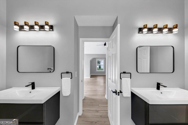 5195 Oaks Landing Ct, Sugar Hill, GA 30518 - bathroom featuring two vanities and wood finished floors