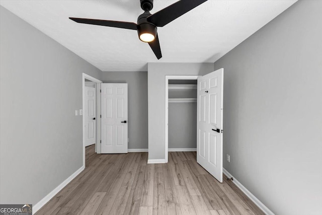 5195 Oaks Landing Ct, Sugar Hill, GA 30518 - unfurnished bedroom featuring light wood-style flooring, a closet, and a ceiling fan