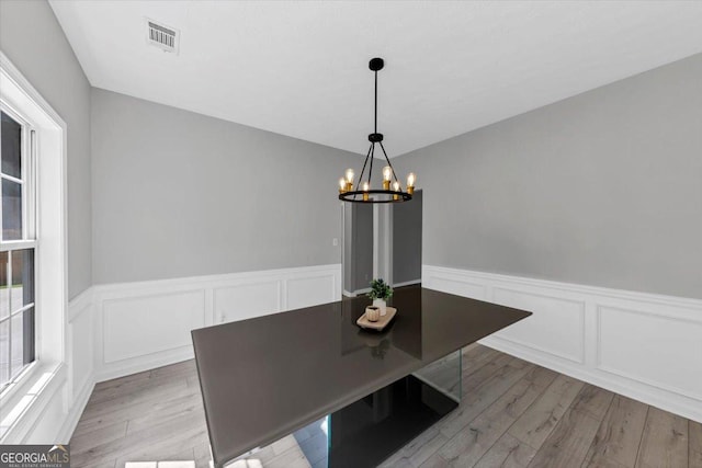 5195 Oaks Landing Ct, Sugar Hill, GA 30518 - unfurnished dining area featuring wood finished floors, a chandelier, a wainscoted wall, and a decorative wall