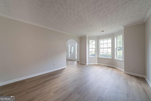 4815 Price St, Forest Park, GA 30297 - spare room featuring arched walkways, wood finished floors, crown molding, and a textured ceiling